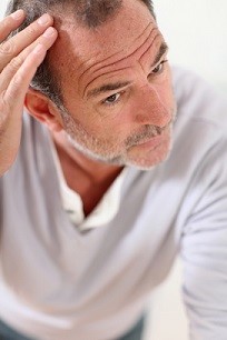 Senior man looking at his hair in mirror