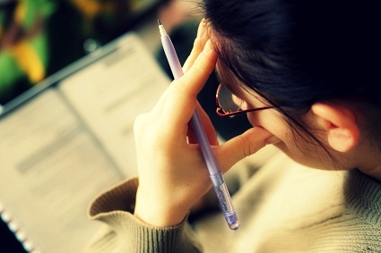 female college student doing test at home. selective dof
