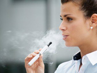 young woman smoking electronic cigarette outdoor office building