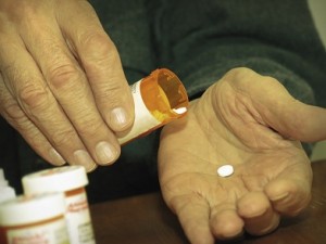 person pouring prescription pill onto hand