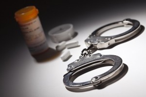 Handcuffs, Medicine Bottle and Pills Under Spot Light Abstract.