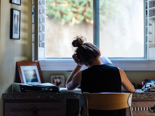 stressed student studying at desk at home